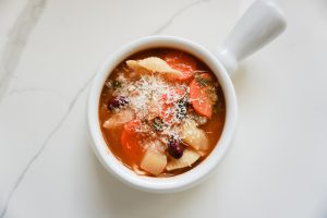 minestrone soup in a bowl with cheese on top