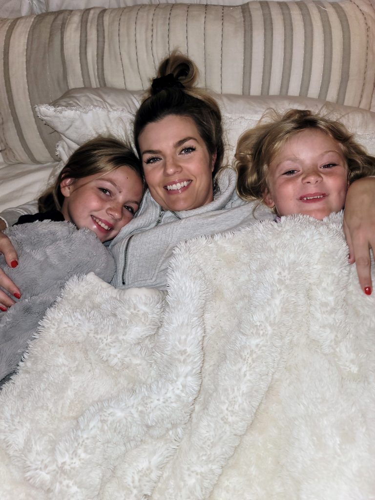 mother uses medicine with flavorings to help children when sick
mother snuggles in bed with two daughters